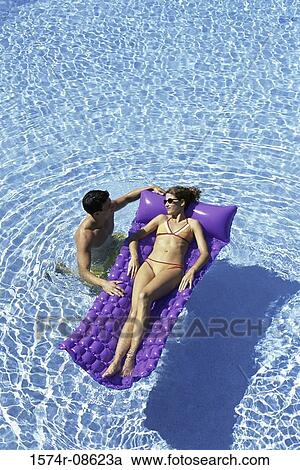 High angle view of a young couple together in a swimming pool View Large Photo Image Stock Image - High angle view of a young couple together in a swimming pool. Fotosearch