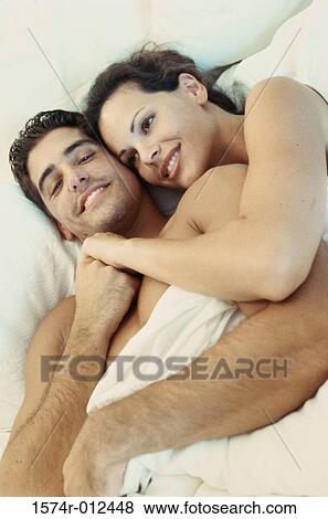 High angle view of a young couple embracing in bed View Large Photo Image Stock Photo - High angle view of a young couple embracing in bed. Fotosearch