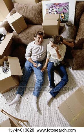 Stock Photo - High angle view of a young couple sitting on the floor. Fotosearch