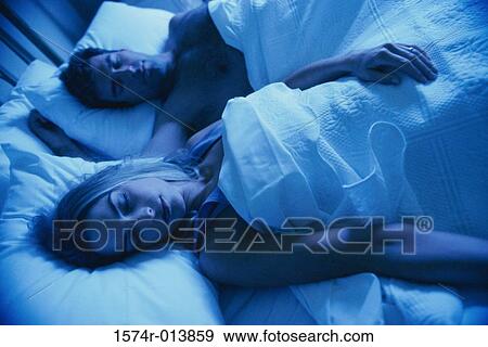 High angle view of a young couple sleeping in bed View Large Photo Image Stock Photo - High angle view of a young couple sleeping in bed. Fotosearch