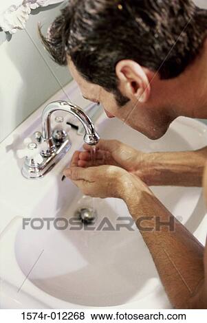 High angle view of a young man washing his face in the bathroom sink View Large Photo Image Stock Photo - High angle view of a young man washing his face in the bathroom sink. Fotosearch