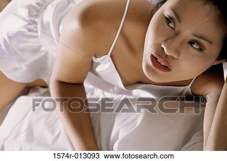 High angle view of a young woman lying in bed View Large Photo Image Stock Image - High angle view of a young woman lying in bed. Fotosearch