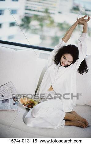 High angle view of a young woman stretching on a couch View Large Photo Image Stock Photography - High angle view of a young woman stretching on a couch. Fotosearch