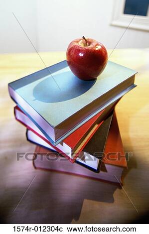 Stock Image - High angle view of an apple on a stack of books. Fotosearch