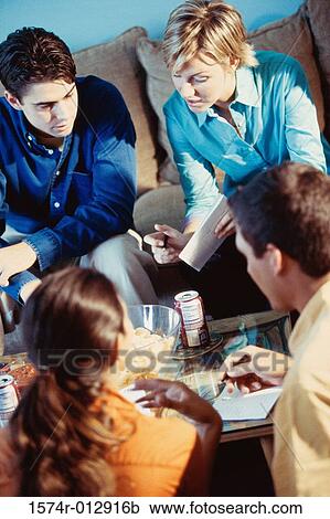 Stock Image - High angle view of four teenagers sitting at a table. Fotosearch