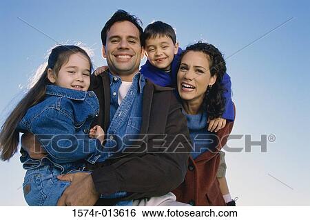 Stock Photograph - High angle view of parents and their two children lying in bed. Fotosearch