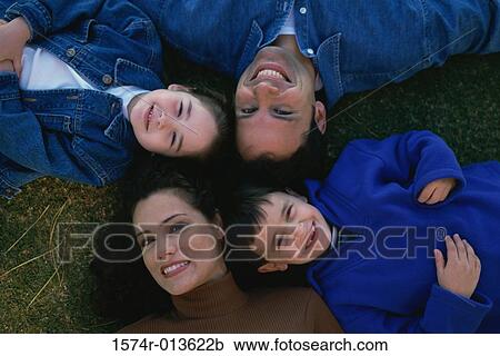 High angle view of parents lying on the grass with their son and daughter View Large Photo Image Stock Image - High angle view of parents lying on the grass with their son and daughter. Fotosearch