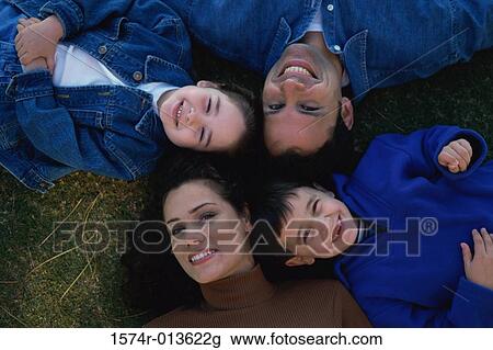 High angle view of parents smiling with their two children View Large Photo Image Stock Image - High angle view of parents smiling with their two children. Fotosearch
