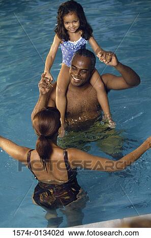 High angle view of parents with their daughter in a swimming pool View Large Photo Image Stock Image - High angle view of parents with their daughter in a swimming pool. Fotosearch