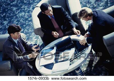 Stock Image - High angle view of three businessmen sitting together. Fotosearch