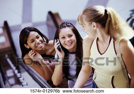 High angle view of three teenage girls standing on an escalator View Large Photo Image Stock Image - High angle view of three teenage girls standing on an escalator. Fotosearch