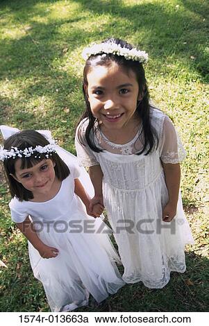 Stock Image - High angle view of two flower girls smiling. Fotosearch