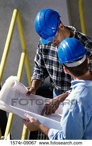 High angle view of two foremen working on blueprints View Large Photo Image Stock Photo - High angle view of two foremen working on blueprints. Fotosearch