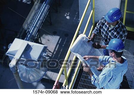 High angle view of two foremen working on blueprints View Large Photo Image Stock Photo - High angle view of two foremen working on blueprints. Fotosearch
