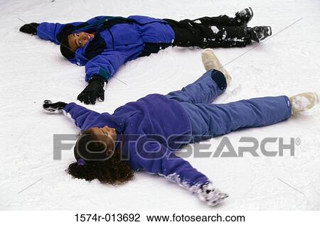 High angle view of two girls making snow angels View Large Photo Image Stock Image - High angle view of two girls making snow angels. Fotosearch