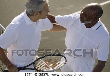 Stock Image - High angle view of two senior men looking at each other. Fotosearch