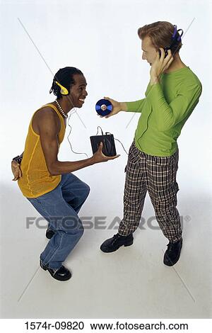 Stock Image - High angle view of two young men wearing headphones. Fotosearch