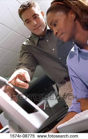 Low angle view of a businessman and a businesswoman in an office View Large Photo Image Stock Photography - Low angle view of a businessman and a businesswoman in an office. Fotosearch