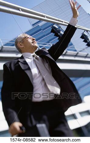 Stock Image - Low angle view of a businessman waving. Fotosearch