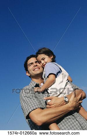 Low angle view of a father carrying his daughter View Large Photo Image Stock Image - Low angle view of a father carrying his daughter. Fotosearch