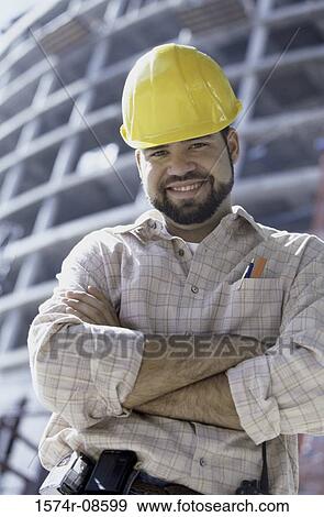 Low angle view of a foreman standing at a construction site smiling View Large Photo Image Stock Photo - Low angle view of a foreman standing at a construction site smiling. Fotosearch