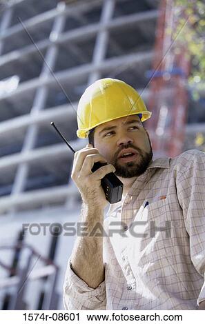 Low angle view of a foreman talking on a walkie-talkie View Large Photo Image Stock Image - Low angle view of a foreman talking on a walkie-talkie. Fotosearch