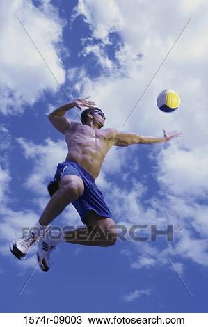 Low angle view of a man playing beach volleyball View Large Photo Image Stock Image - Low angle view of a man playing beach volleyball. Fotosearch