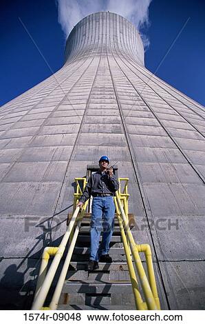 Low angle view of a man standing on a staircase of a smoke stack at a power plant View Large Photo Image Stock Photo - Low angle view of a man standing on a staircase of a smoke stack at a power plant. Fotosearch