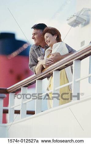 Low angle view of a mature couple standing on the deck of a cruise ship View Large Photo Image Stock Image - Low angle view of a mature couple standing on the deck of a cruise ship. Fotosearch