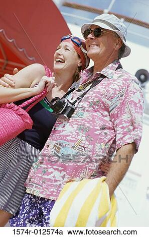 Stock Image - Low angle view of a mature couple smiling. Fotosearch