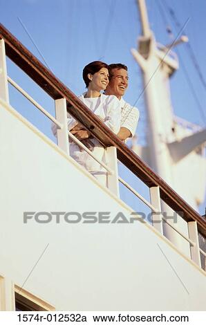 Low angle view of a mid adult couple standing on the deck of a cruise ship smiling View Large Photo Image Stock Image - Low angle view of a mid adult couple standing on the deck of a cruise ship smiling. Fotosearch