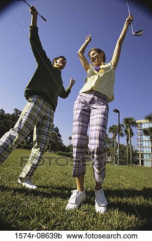 Low angle view of a mid adult man and a mid adult woman at a golf course View Large Photo Image Stock Image - Low angle view of a mid adult man and a mid adult woman at a golf course. Fotosearch