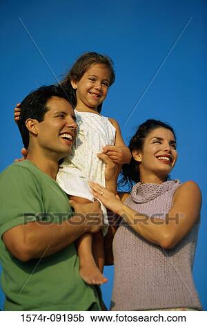 Stock Image - Low angle view of a mother and father with their daughter. Fotosearch