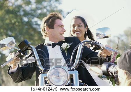 Low angle view of a newlywed couple riding a motorcycle View Large Photo Image Stock Image - Low angle view of a newlywed couple riding a motorcycle. Fotosearch