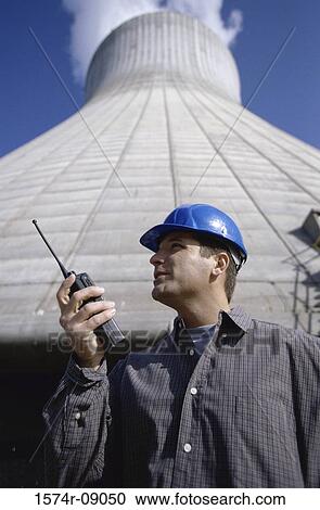 Low angle view of a worker holding a walkie-talkie standing beside a smoke stack at a power plant View Large Photo Image Stock Image - Low angle view of a worker holding a walkie-talkie standing beside a smoke stack at a power plant. Fotosearch