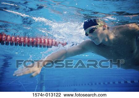 Low angle view of a young man swimming underwater in a swimming pool View Large Photo Image Stock Image - Low angle view of a young man swimming underwater in a swimming pool. Fotosearch