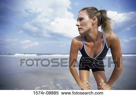 Low angle view of a young woman bending forward on the beach View Large Photo Image Stock Photography - Low angle view of a young woman bending forward on the beach. Fotosearch