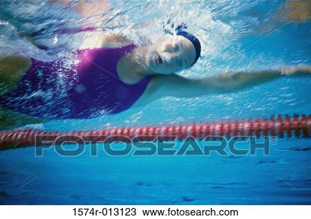 Low angle view of a young woman swimming underwater in a swimming pool View Large Photo Image Stock Image - Low angle view of a young woman swimming underwater in a swimming pool. Fotosearch