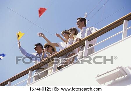 Stock Image - Low angle view of five people waving their hands on the deck of a cruise ship. Fotosearch