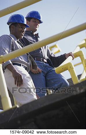 Low angle view of two construction workers View Large Photo Image Stock Image - Low angle view of two construction workers. Fotosearch