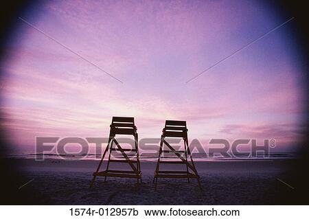 Low angle view of two lifeguard chairs on the beach at dusk View Large Photo Image Stock Image - Low angle view of two lifeguard chairs on the beach at dusk. Fotosearch