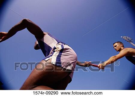 Low angle view of two male athletes passing a relay baton View Large Photo Image Stock Image - Low angle view of two male athletes passing a relay baton. Fotosearch