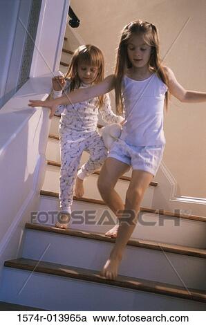 Low angle view of two sisters walking down stairs View Large Photo Image Stock Image - Low angle view of two sisters walking down stairs. Fotosearch