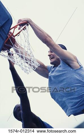 Picture - Low angle view of two young men playing basketball. Fotosearch