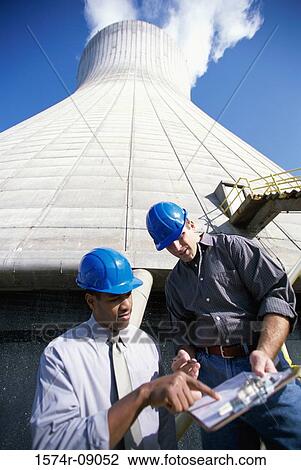 Low angle view of workers standing beside a smoke stack at a power plant View Large Photo Image Stock Image - Low angle view of workers standing beside a smoke stack at a power plant. Fotosearch