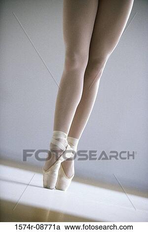 Stock Image - Low section view of a ballerina standing on tiptoe. Fotosearch