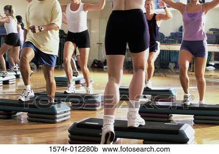 Stock Image - Low section view of a group of people exercising in a step aerobics class. Fotosearch