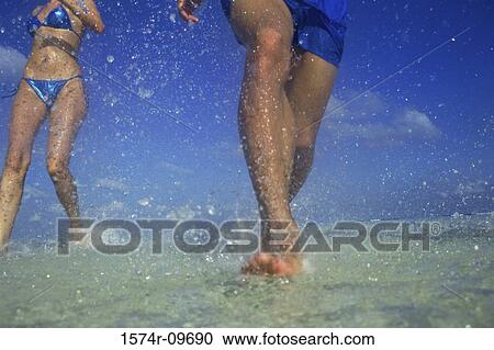 Low section view of a man and woman at the beach View Large Photo Image Stock Image - Low section view of a man and woman at the beach. Fotosearch