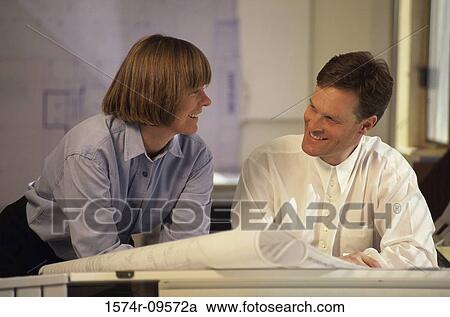 Male and female architects working on blueprints View Large Photo Image Stock Image - Male and female architects working on blueprints. Fotosearch