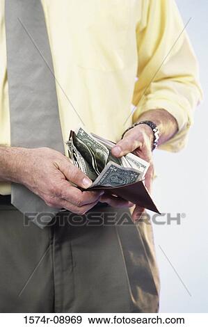 Man holding a wallet with money View Large Photo Image Stock Photo - Man holding a wallet with money. Fotosearch